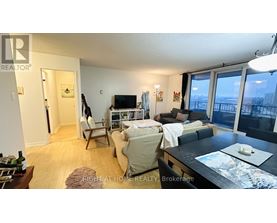 A living room with a couch, chair, and a television.