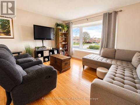 A living room with a grey couch, a grey sofa, a grey chair, a grey ottoman, a grey coffee table, a grey TV stand, a grey plant, a grey wall, a grey window, a grey curtain,