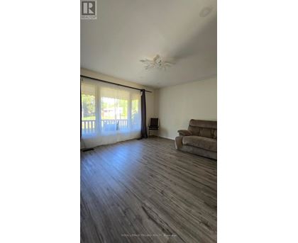 A living room with a brown couch and a ceiling fan.