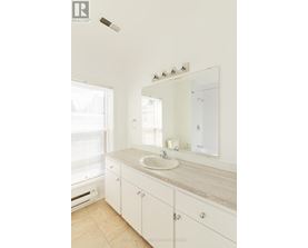 A bathroom with a sink, mirror, and cabinet.