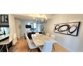 A dining room with a large table and chairs.