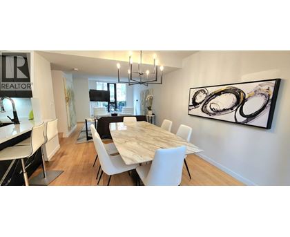 A dining room with a large table and chairs.
