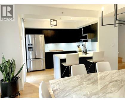A modern kitchen with a dining table and chairs.
