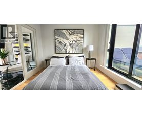 A bedroom with a large bed and a large window.