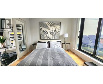 A bedroom with a large bed and a large window.