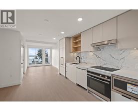 A modern kitchen with white appliances and a marble backsplash.