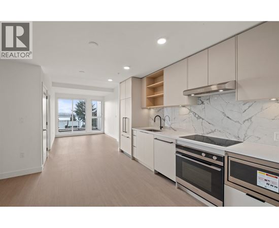 A modern kitchen with white appliances and a marble backsplash.