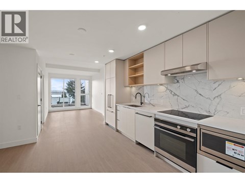 A modern kitchen with white appliances and a marble backsplash.