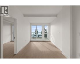 A spacious room with a view of a balcony with a table and chairs.