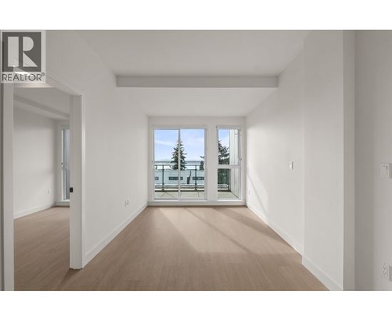 A spacious room with a view of a balcony with a table and chairs.
