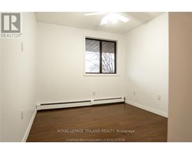A white room with a window and a ceiling fan.