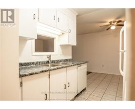 A kitchen with white cabinets and a marble countertop.