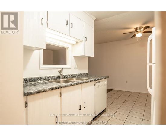 A kitchen with white cabinets and a marble countertop.