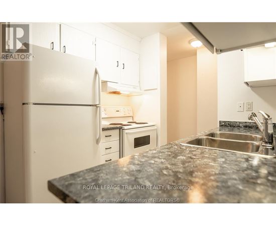 A kitchen with a granite countertop and white appliances.