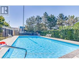 A swimming pool surrounded by a fence and trees.