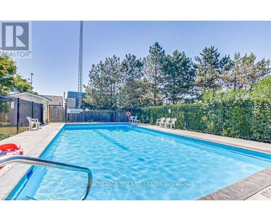 A swimming pool surrounded by a fence and trees.