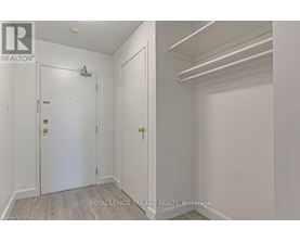 A white door with a gold handle is in a room with white walls.