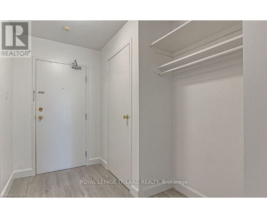 A white door with a gold handle is in a room with white walls.