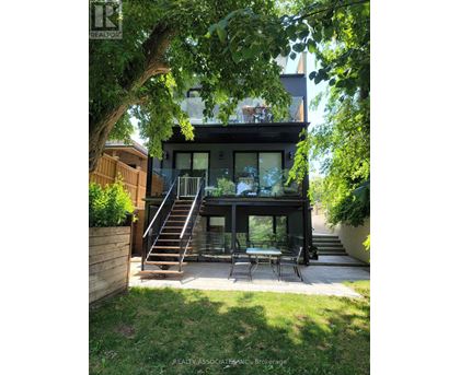 A modern house with a glass table and chairs in the backyard.