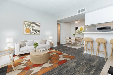 A living room with a white couch, a coffee table, and a painting on the wall.