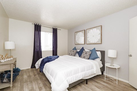 A bedroom with a white bed and a white nightstand.