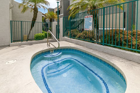 A small pool with a ladder and a sign on the fence.