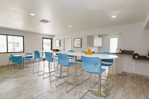 A kitchen with blue chairs and a white table.