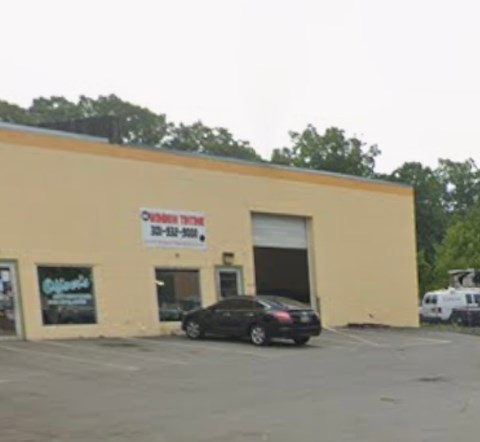 A car dealership with a sign that says "Cadillac" on the window.