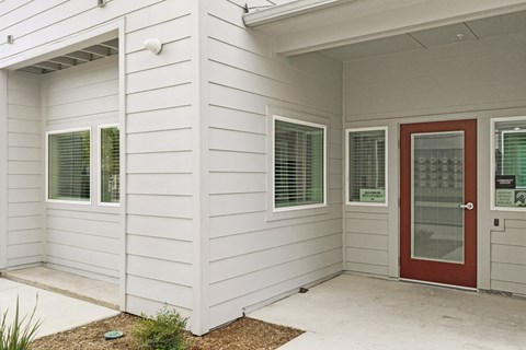 A white house with a red door and windows.