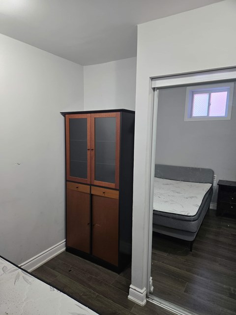 A bedroom with a bed, a wardrobe and a window.