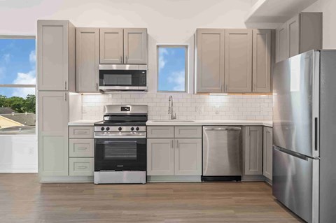 A kitchen with a stove, oven, refrigerator, and microwave.