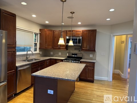 A kitchen with wooden cabinets and a granite countertop.