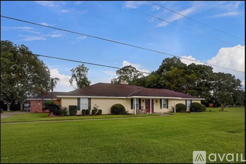 A house with a red door and a green lawn in front.