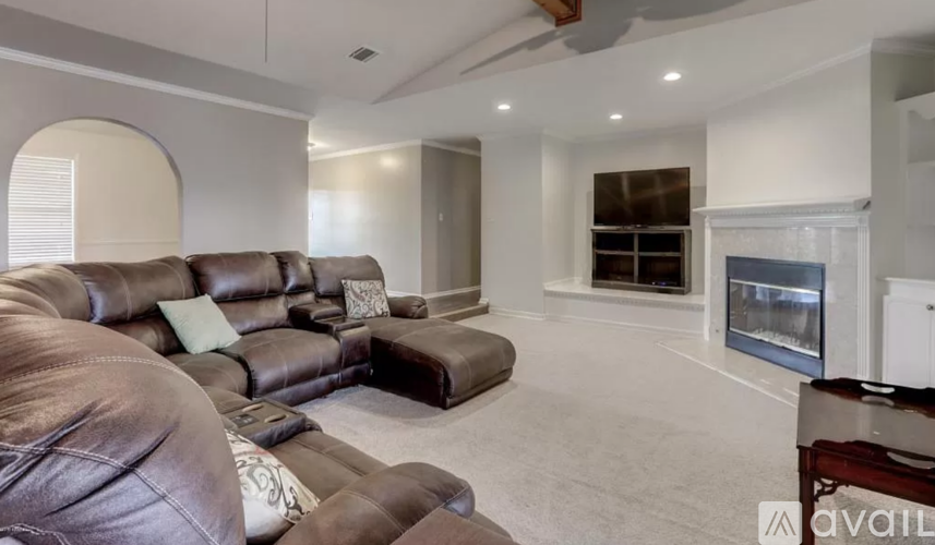 A living room with a brown leather couch and a white wall.