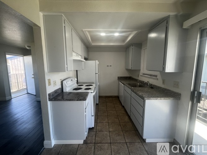 A kitchen with white appliances and cabinets.