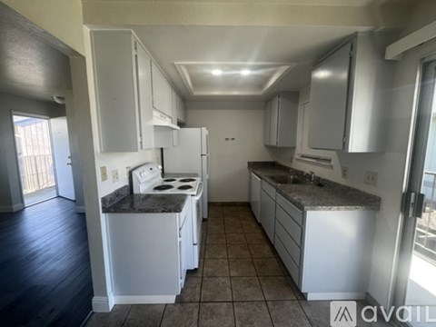 A kitchen with white appliances and cabinets.