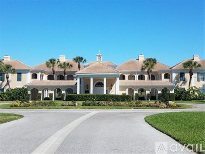 A large, luxurious house with a driveway in front.