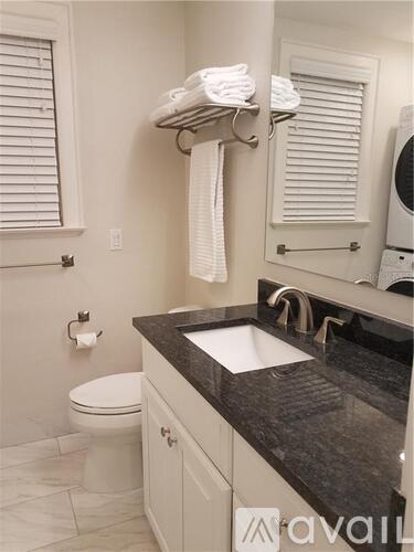 A bathroom with a toilet, sink, and towel rack.