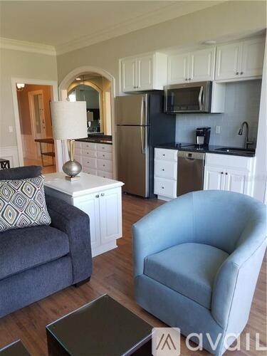 A living room with a grey couch, a blue armchair, and a coffee table.