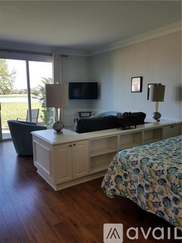 A bedroom with a bed, a couch, and a television.