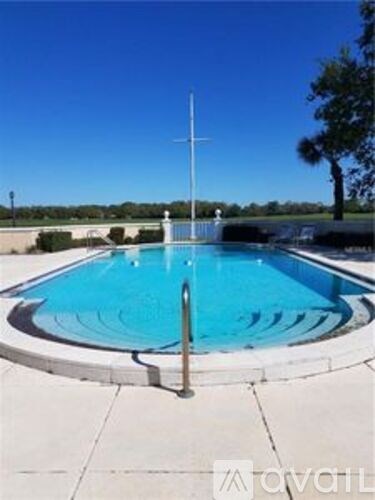 A swimming pool with a diving board and a pole in the middle.
