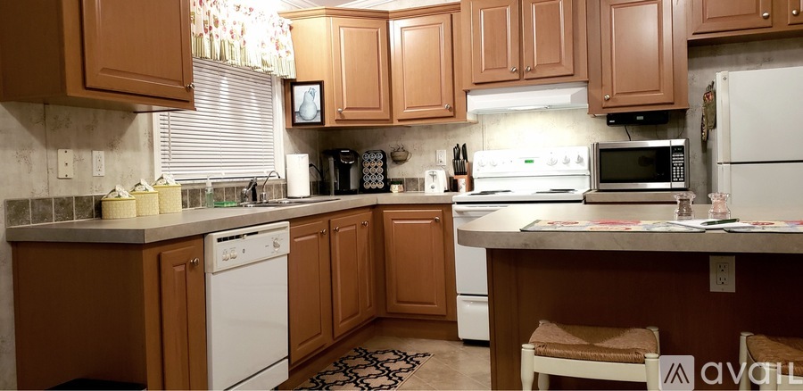 A kitchen with brown cabinets and a white dishwasher.