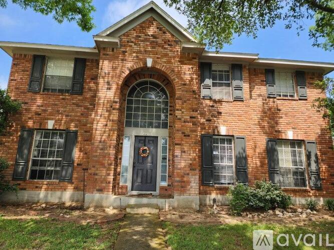 A brick house with a black door and windows.