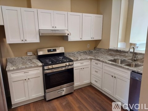 A kitchen with white cabinets and a granite countertop.