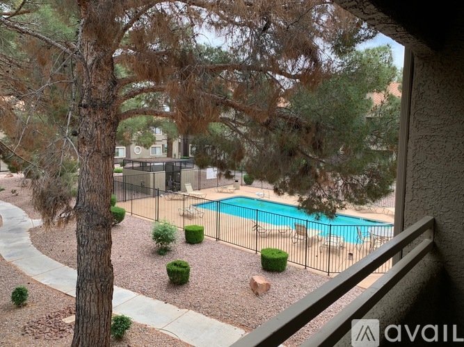 A pool surrounded by a fence and trees.