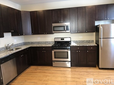 A kitchen with dark brown cabinets and stainless steel appliances.