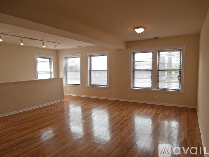 Empty room with wooden floors and windows.