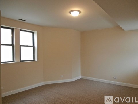 A room with a carpeted floor and a window.