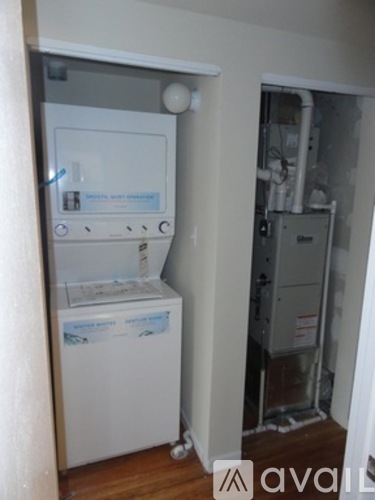 A white fridge in a room with a door open.