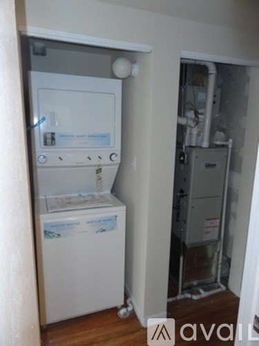 A white fridge in a room with a door open.